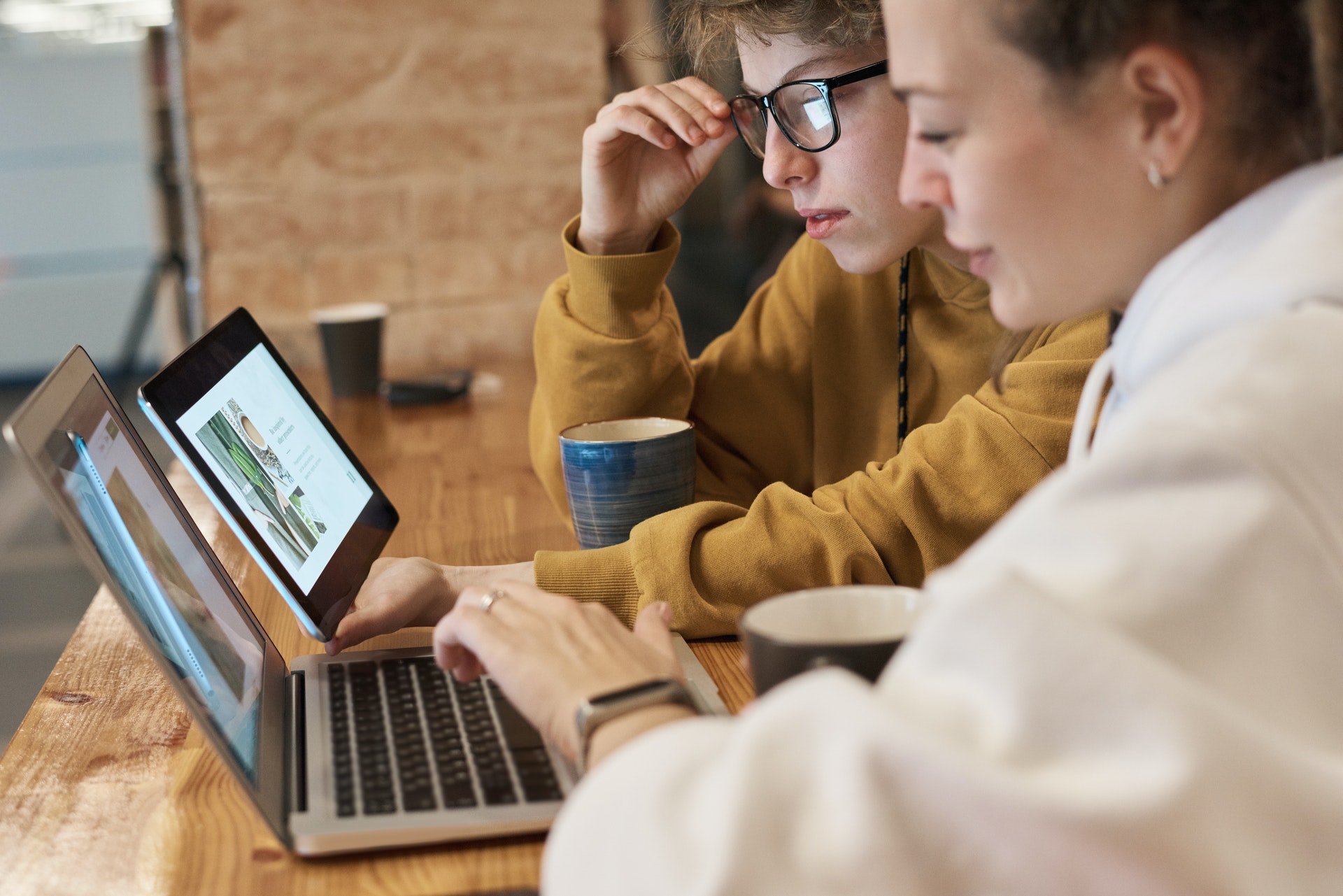 Two women looking at laptop and tablet