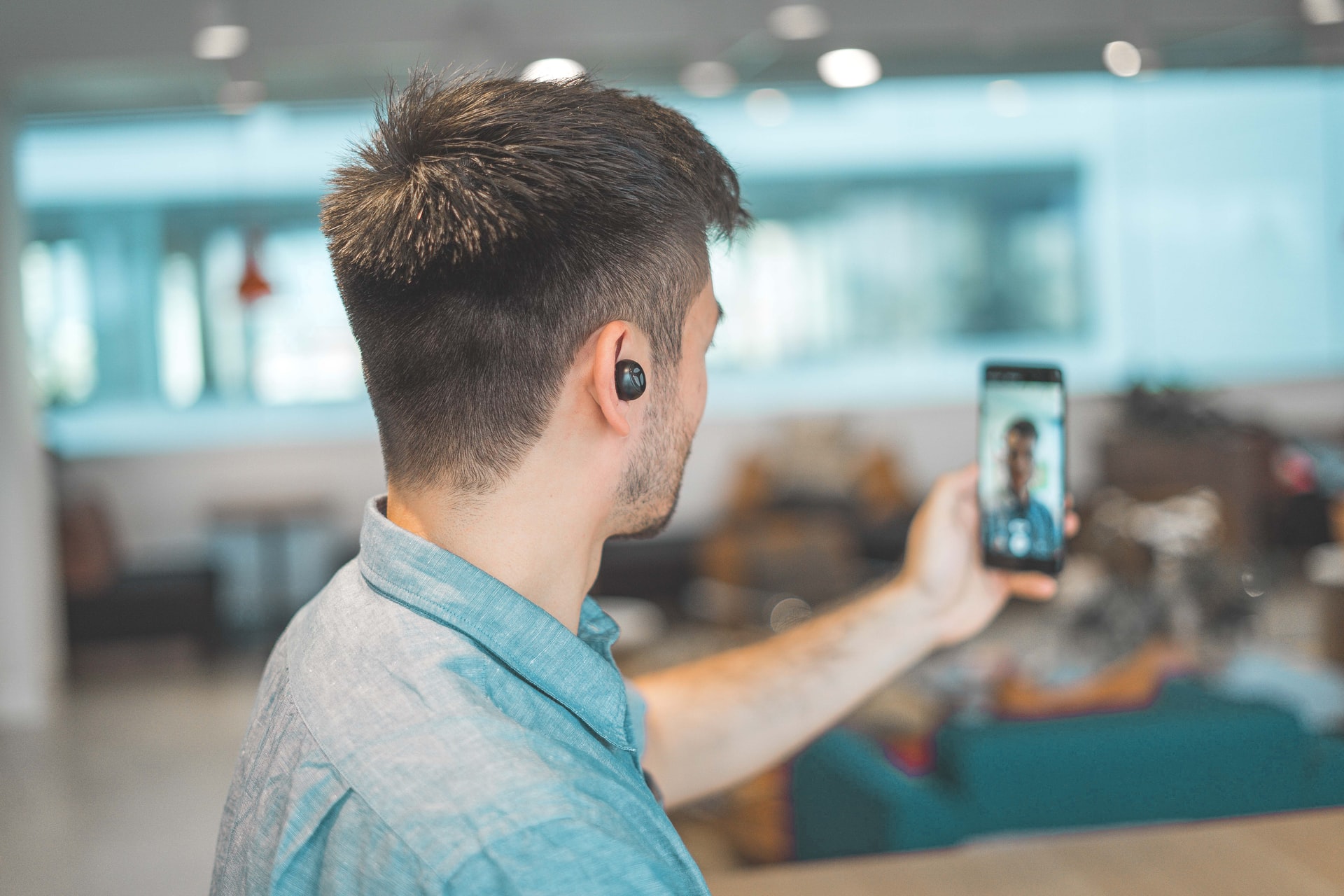 man in shirt creating video on celllphone