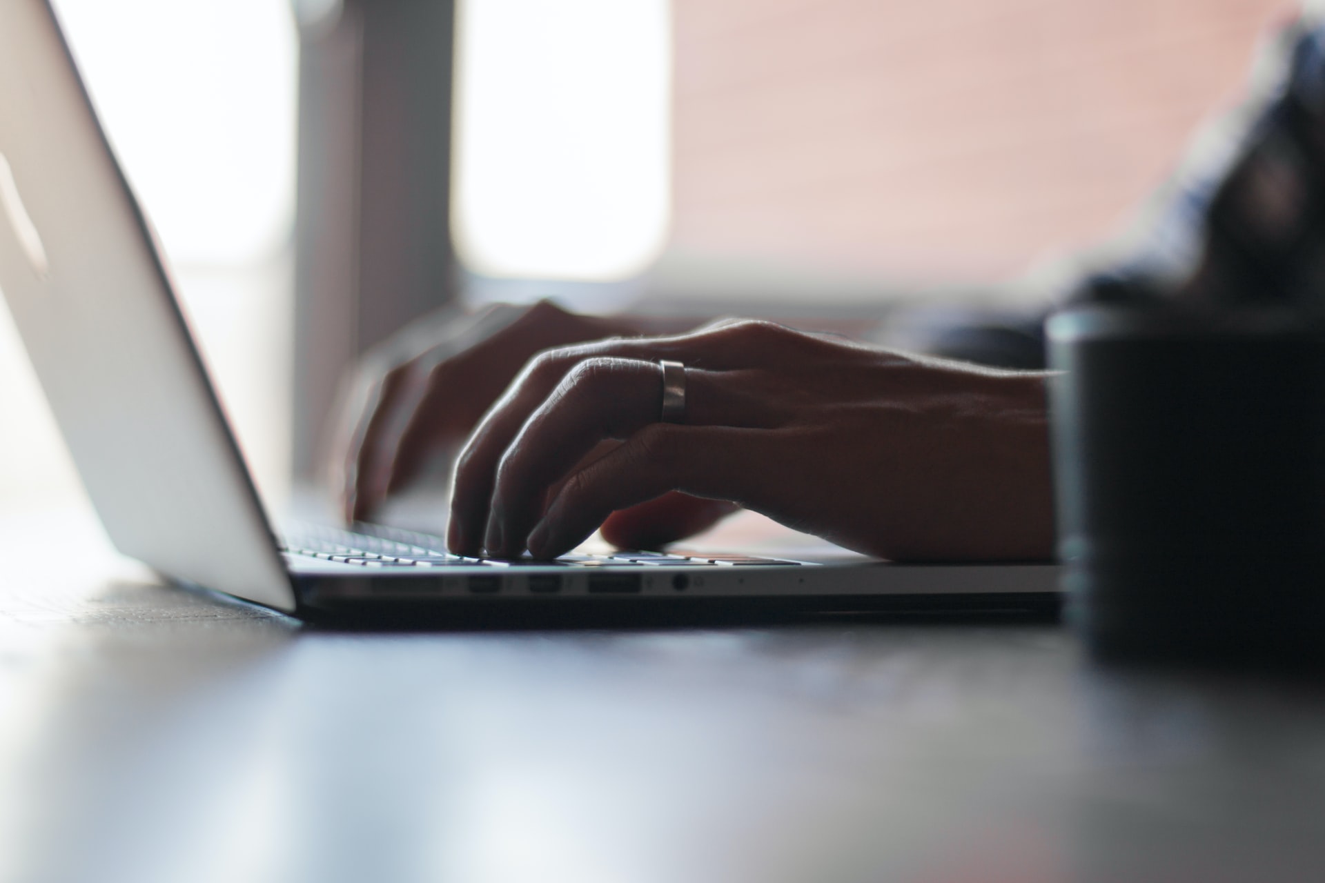 Person wearing ring working on laptop