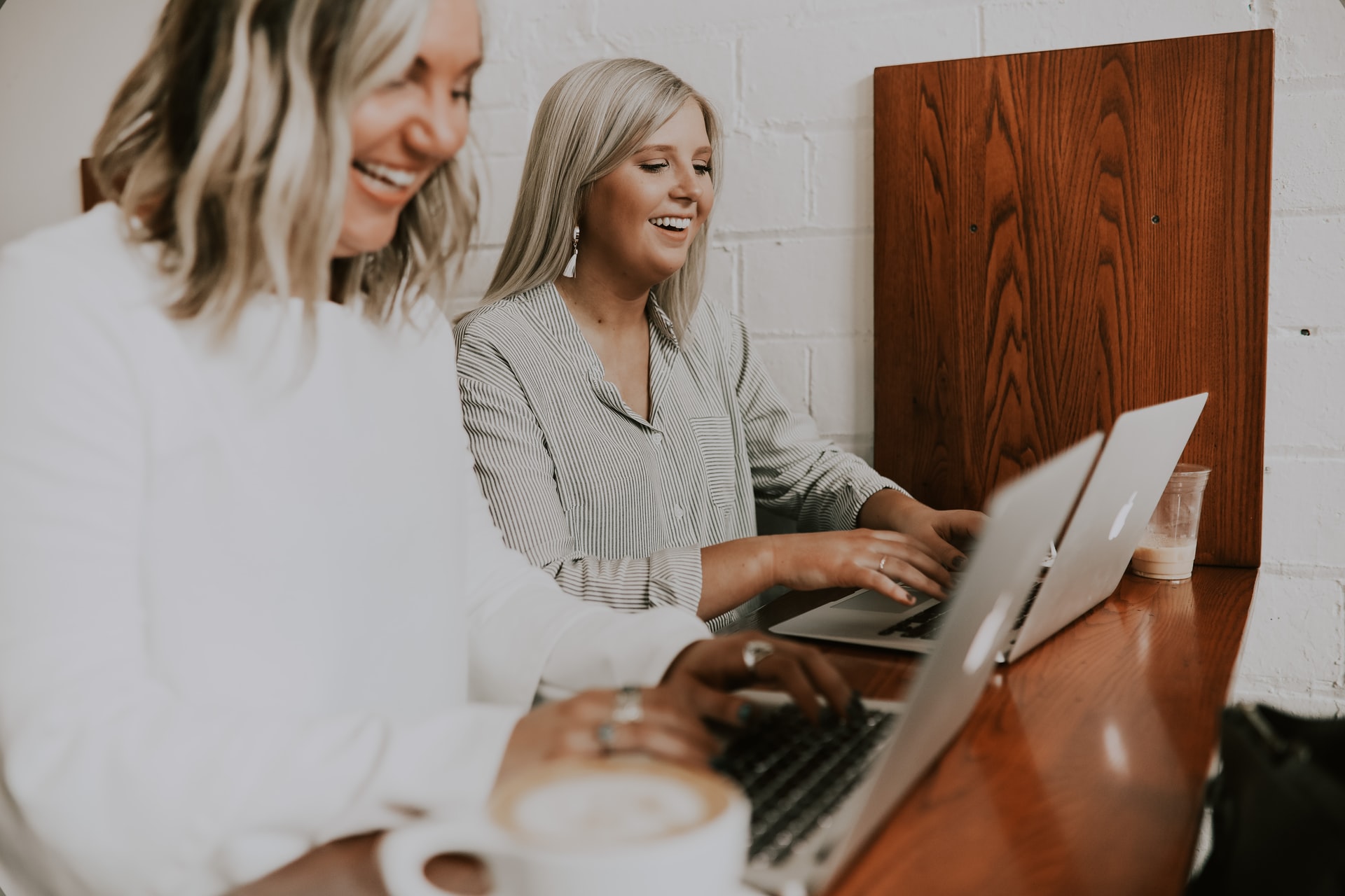 Two blond girls working on their laptops